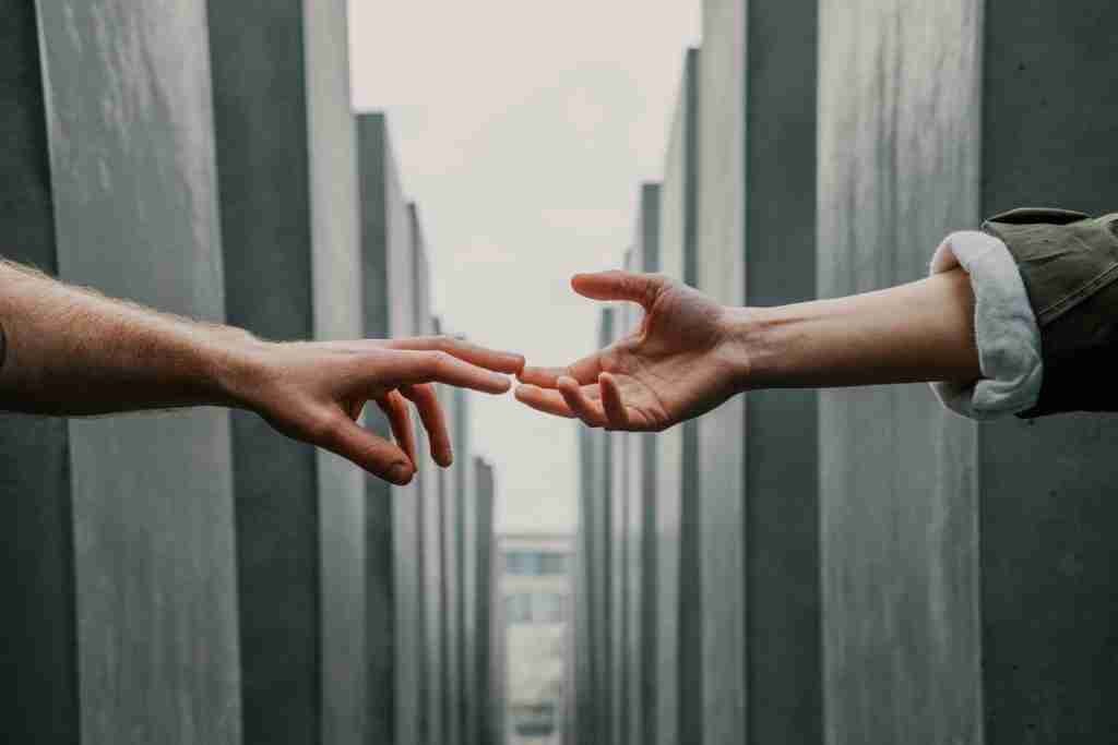 psicoterapia e intelligenza artificiale rappresentate da due mani che si tendono e che spuntano da strutture cibernetiche apparentemente distanti tra di loro